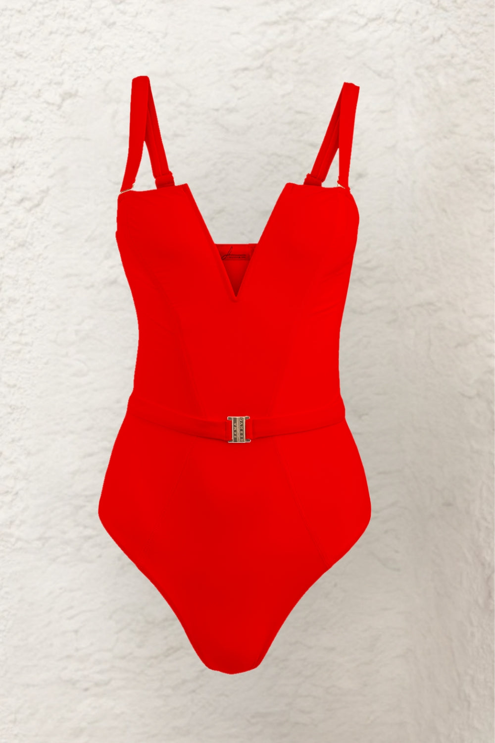 A cut out close-up from the front of a woman's bright red swimwear, highlighting straps, the deep V-shaped neckline and gold buckle detail for an elegant touch