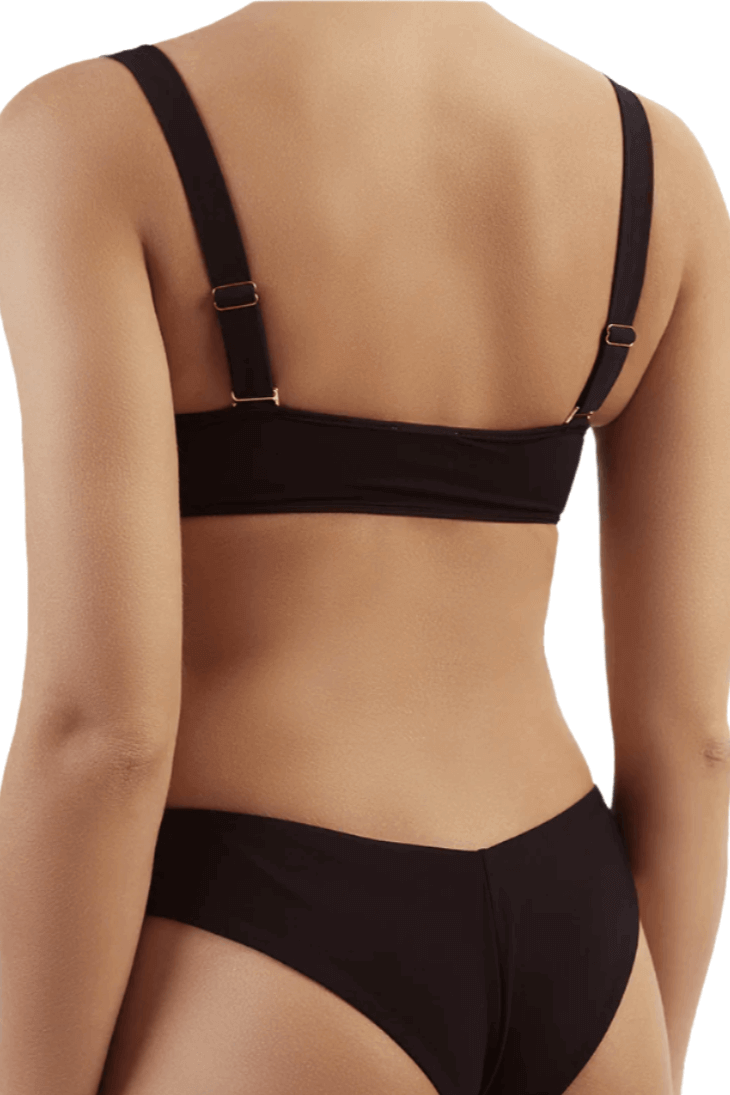 A women posing from the back in a Sama Danesh black underwire padded bikini top with thick removable straps, showcasing the sleek design and flattering fit.